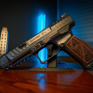 Canik SFx Rival-S pistol on stand, blue backlight, left angle