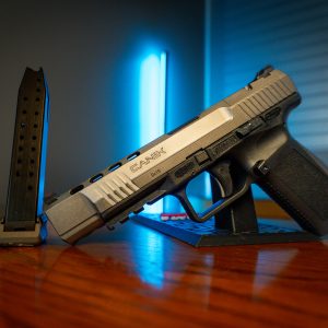 Canik TP9SFx pistol with magazines on wood table, left angle