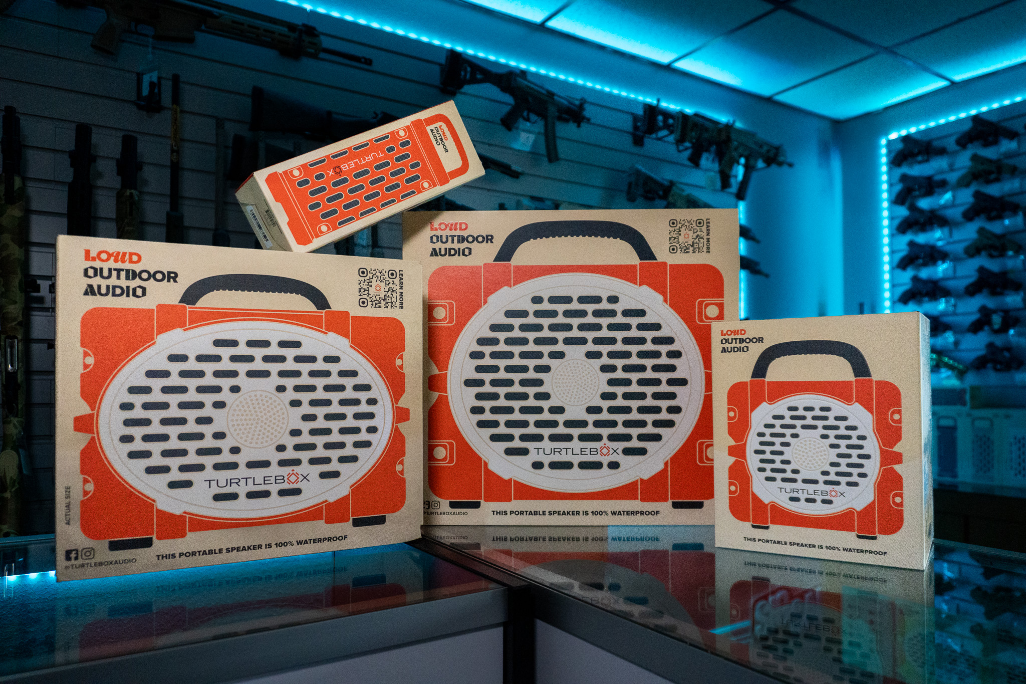 Turtlebox speakers of three sizes in orange retail boxes