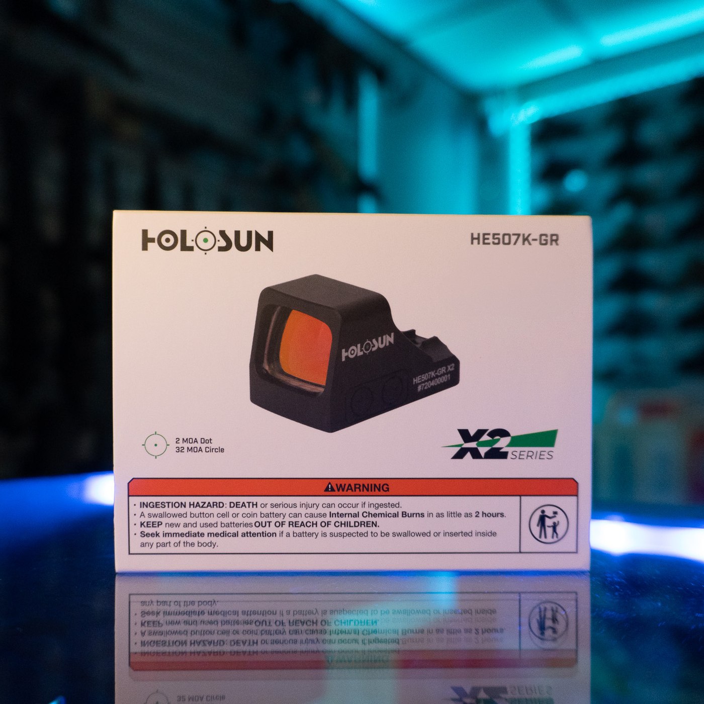 Holosun HE507K-GR X2 green multi-reticle micro pistol sight in its retail box on a glass display counter