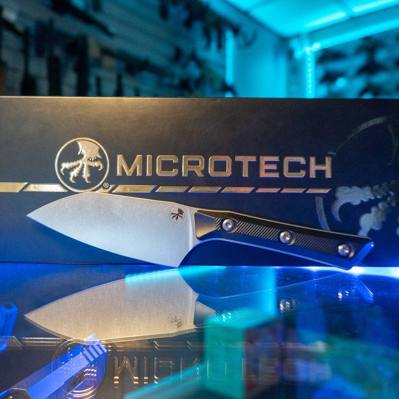 Microtech 4 inch Santoku kitchen knife with stonewash M390MK blade and black G-10 handle in front of its Microtech box