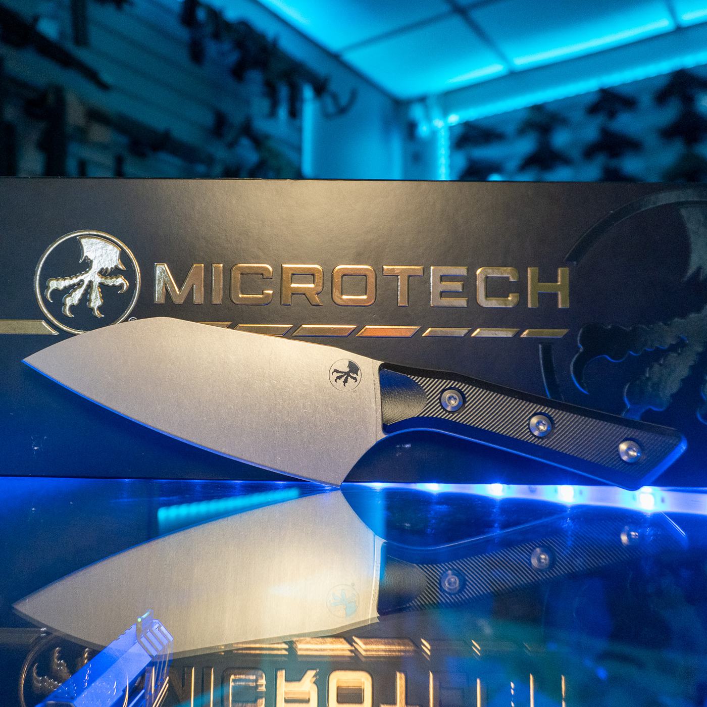 Microtech 6 inch Santoku kitchen knife with stonewash M390MK blade and black G-10 handle in front of its Microtech box